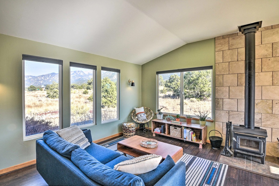 Living room with wood stove and mountain windows