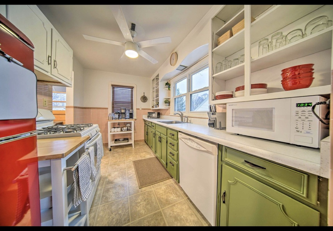 Kitchen with green cabinets and full-size range